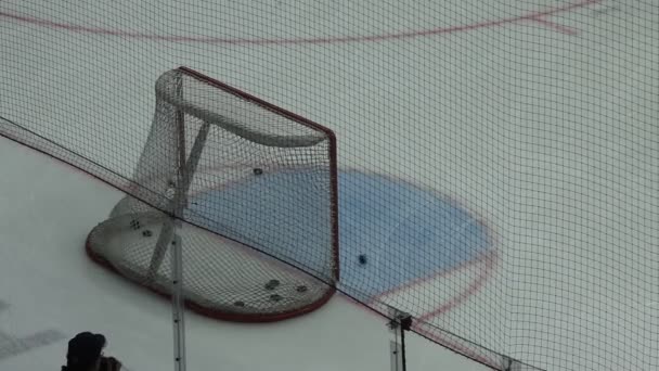 Jugador de hockey dispara varios discos a los objetivos en la puerta, primer plano
 - Metraje, vídeo