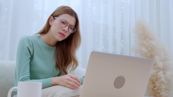 Young asian woman wearing glasses sitting on sofa worried with bills about financial and stress at home, unhappy woman frustrated and anxiety about loan with overdue or tax, business and lifestyle. - Footage, Video