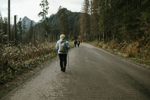 Wandelen, volwassen Kaukasische senior vrouw in de natuur voor oefening, vakantie wandelen en genieten van de bergen. Reizen, pensioen en een oudere man en vrouw op een wandeling in het bos of bos voor trekking - Foto, afbeelding