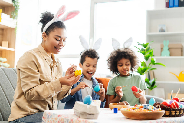 Ritratto felice famiglia latina indossa orecchie di coniglio pittura uova preparazione insieme per le vacanze di Pasqua  - Foto, immagini