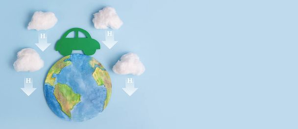 Coche verde, planeta tierra y símbolo del átomo de hidrógeno H2. Transporte ecológico. Reducción de emisiones de dióxido de carbono. Medio ambiente. Banner. - Foto, imagen