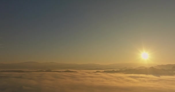 Вид з повітря Золоте світло ранкового сонця над морем туману. У долині створюється спокійна вечірня атмосфера. Барвисті кольори гірського масиву - Кадри, відео