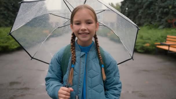 Close up dívka stojící město ulice mimo deštník deštivé počasí svěžest vlhkost pokles meteorologie klima jaro radost štěstí vzduch relax dítě usměvavý odpočinek mokrý vodopád radostný - Záběry, video