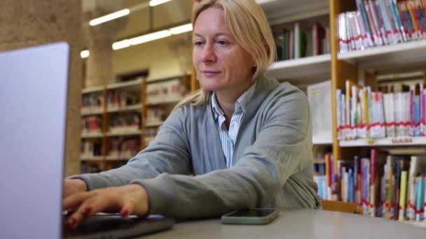 Žena dospělý student učení nový vzdělávací předmět v knihovně Žena středního věku pomocí notebooku ve studiu a výzkumu pro vědecké materiály on-line v Internetu. Aktualizovat odbornou kvalifikaci - Záběry, video