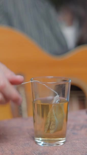 Young bearded musician drinking a tea whilst broadcasting a song online - Close up shot - Záběry, video