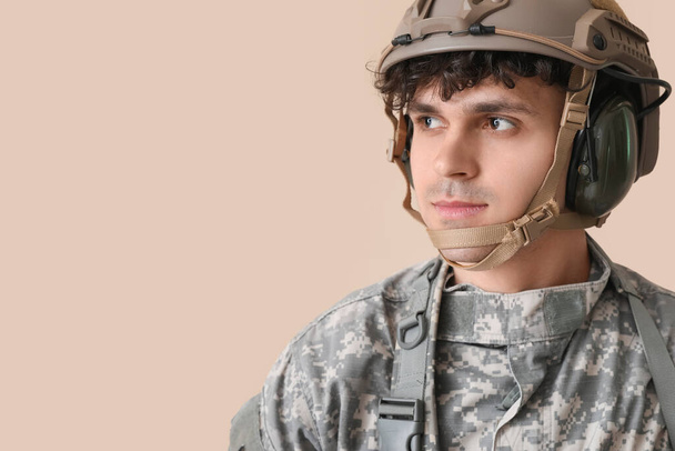Young male soldier on beige background, closeup - Photo, Image