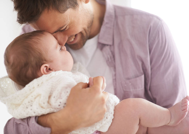Baby, girl and dad holding with smile, proud and fathers day in family home. Parents, infant and love embrace for eskimo kiss, growth and healthy child development in nursery for affection parenting. - Photo, Image