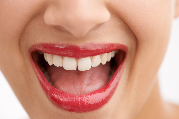 Šťastná žena, zuby a červená rtěnka s make-upem pro krásu, kosmetiku nebo zubní péči na bílém pozadí studia. Detailní záběr osoby nebo modelu ve spokojenosti pro lesk rtů, lesk nebo bělení zubů. - Fotografie, Obrázek