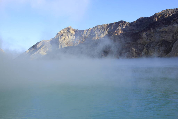 Haze kattaa pinnan Ijen kraatteri järvi, joka on sininen ja on korkea happamuus johtuen rikkipitoisuus. - Valokuva, kuva