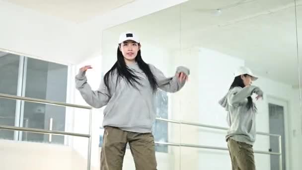 Cheerful young woman practicing dance in studio. Youth culture, movement and hobby concept.  - Footage, Video