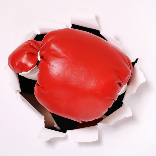 Hand in boxing glove through paper hole - Φωτογραφία, εικόνα