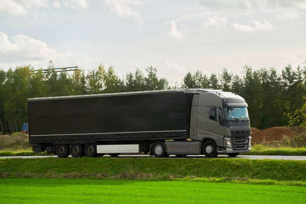 Áruk szállítása és szállítása félpótkocsikkal. A teherautók teherkonténerekkel mennek az úton. A fenntartható és hatékony közlekedési rendszer koncepciója. Földlogisztikai ipari makettek. - Fotó, kép