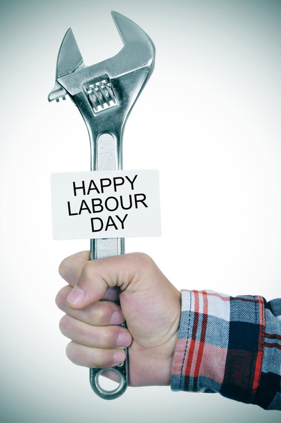 Man with adjustable wrench and signboard with text happy labour - Photo, Image