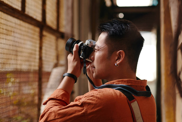Fotograaf loopt rond in de oude binnenstad en maakt foto 's van verlaten gebouwen - Foto, afbeelding