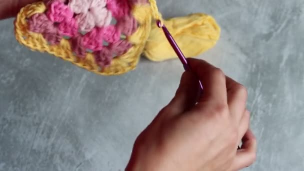 Close up vídeo de mãos segurar crochê vovó quadrado. Mulher crochê colorido ornamento de algodão. Conceito de hobby e lazer.  - Filmagem, Vídeo