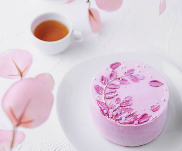 Шматочок шоколадного торта з рожевим кремом і чаєм - Фото, зображення