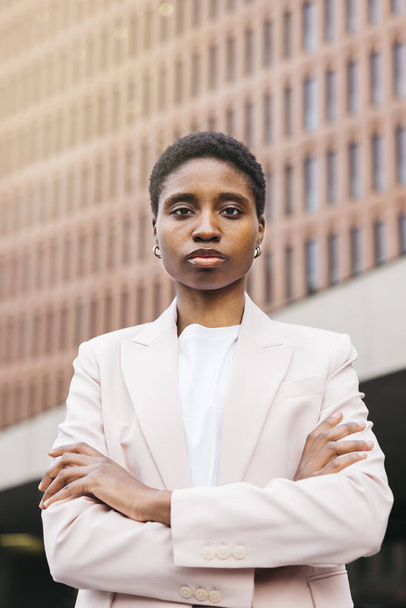 Retrato de una joven y hermosa empresaria africana en la calle rodeada de edificios de oficinas. - Foto, Imagen
