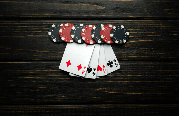 Le jeu de poker populaire avec une combinaison gagnante de quatre d'un genre ou quads est également intéressant. Chips et cartes sur une table vintage sombre dans un club de poker. - Photo, image