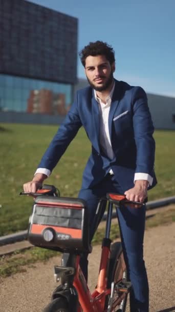 Uomo d'affari ispanico in bicicletta e sorridente alla macchina fotografica. . Filmati di alta qualità - Filmati, video