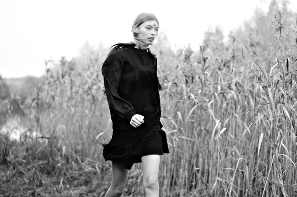 ファッション モデルの女性が黒のドレスで実行します。自然の背景. - 写真・画像