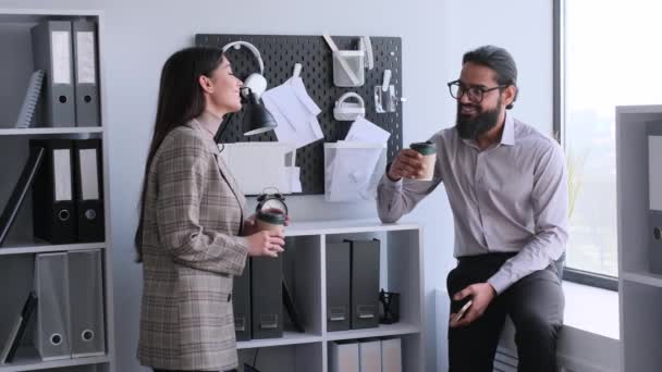 Successful and happy colleagues relaxing in break in office, talking and cheers with paper cups with beverages, tea or coffee. Leisure time in office. - Footage, Video