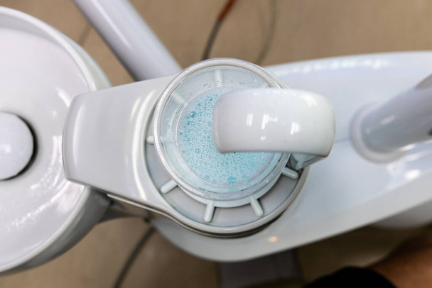 Blick auf das mit CHX-Mundspüllösung gefüllte Einwegglas neben der Spiotoon-Schüssel in der Zahnklinik - Foto, Bild