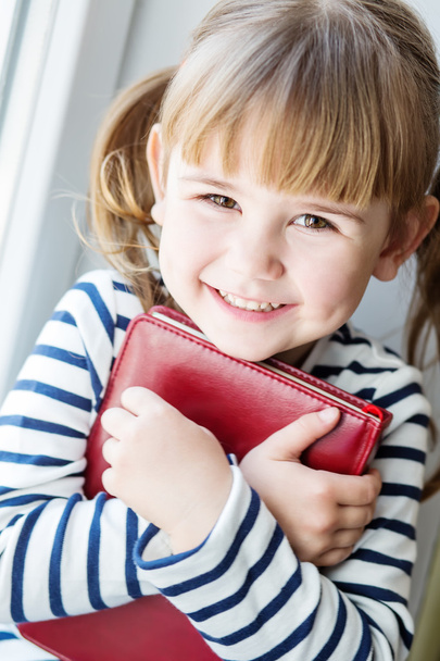 glückliches kleines Mädchen mit einem Buch in der Hand  - Foto, Bild