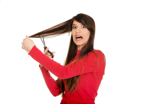 junge Frau schneidet sich die Haare. - Foto, Bild