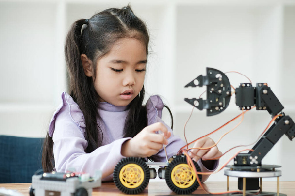 Aasialainen tyttö keskittyy rakentamaan robotti, johon STEM-koulutus. - Valokuva, kuva