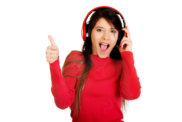 Woman with thumb up listening to music. - Foto, imagen