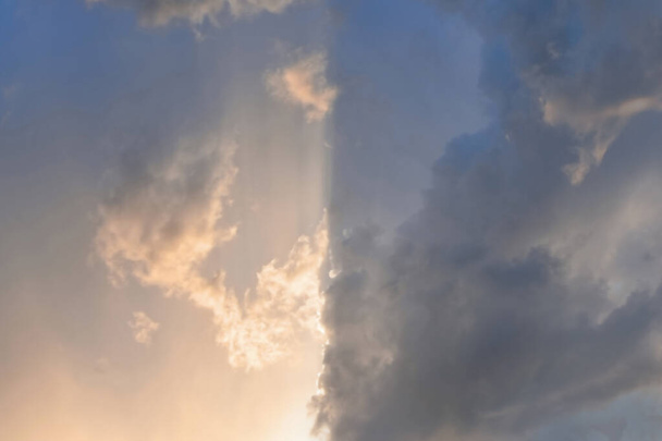 Ciel nuageux divisé en parties claires et sombres, éclairé par la lumière du soleil - Photo, image