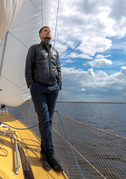 Karcsú ember vitorla alatt áll egy jachton a Balti-tengeren, Rigában. Lettország. Fogalma egy rövid nyaralás a vízen. Nyugodt ember.. - Fotó, kép