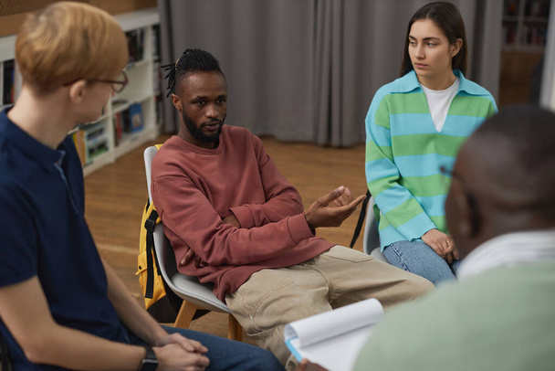 Gençler için grup terapisi sırasında psikologla konuşan siyahi bir gencin portresi - Fotoğraf, Görsel