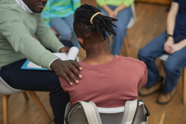 Wysoki kąt widzenia w trudnej czarny mężczyzna płacze w grupie wsparcia koła i dzielenie się historią z terapeutą wsparcia - Zdjęcie, obraz