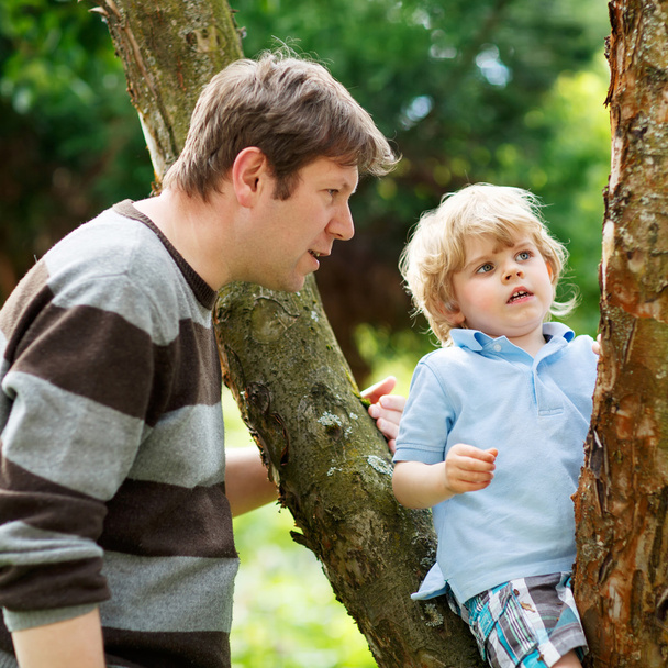 Schattige kleine jongen-jongen genieten van klimmen op boom met vader, overtreffen - Foto, afbeelding