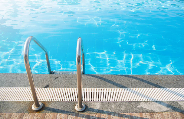 Handgreep ladder in het blauwe zwembad - Foto, afbeelding