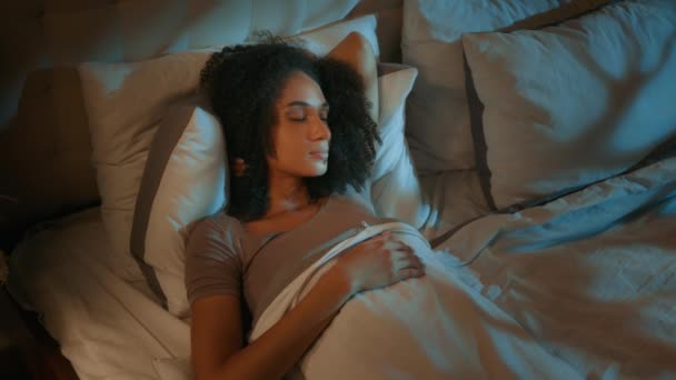 Zavart fiatal nő szunyókál az ágyban ébren zaj irritáció szenved éjszaka álmatlanság zajos szomszéd probléma alvás álmatlanság dobás álmatlan afro-amerikai lány bosszús kényelmetlenség próbál aludni - Felvétel, videó