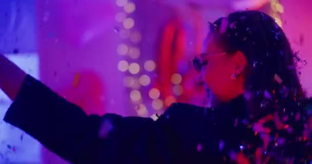 Jovem despreocupada usando óculos de sol dançando em confete durante a festa do dia de Galentines - Filmagem, Vídeo