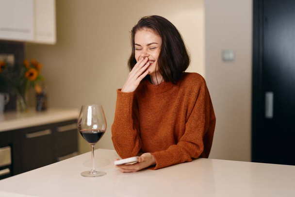 Femme seule, buvant du vin, déprimée et triste, assise à l'intérieur avec un verre à la main - Photo, image