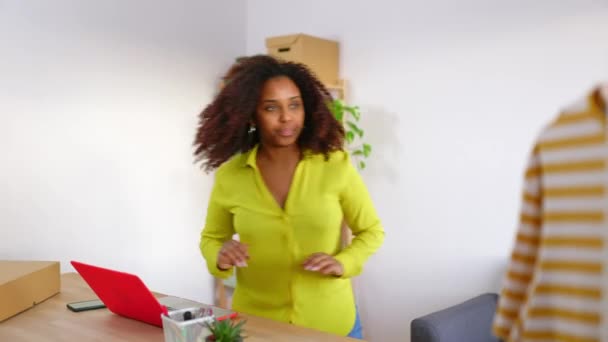 Giovane donna afroamericana proprietaria di piccole imprese che utilizza il computer portatile che lavora in ufficio. Lavoratrice che prepara una nuova consegna in vendita in officina. Concetto di commercio elettronico e imprenditorialità. - Filmati, video