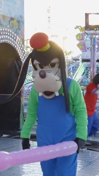 Tren chu chu attraction in a funfair in Valencia. Man in Goofy costumes entertain people with colorful balloons - slow-motion - FullHD Vertical video - Footage, Video