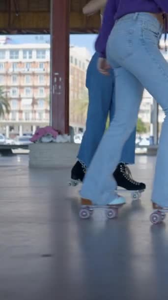 Vista al suelo de las siguientes piernas de las niñas de patinaje sobre ruedas al aire libre - FullHD Vertical video - Metraje, vídeo