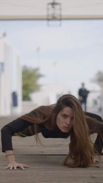 Jovem mulher de cabelos escuros ao ar livre parece louco e rasteja em direção à câmera - 1080 Vídeo vertical - Filmagem, Vídeo