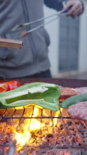 Yüzsüz adam sebzelerin yanındaki ızgaraya hamburgerleri koyuyor - yavaş çekim - FullHD dikey video - Video, Çekim