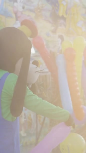 Goofy et Mickey Mouse Disney personnages réconfortant les gens à cheval kidsl train montagnes russes avec des ballons à Valence juste - FullHD Vidéo verticale - Séquence, vidéo