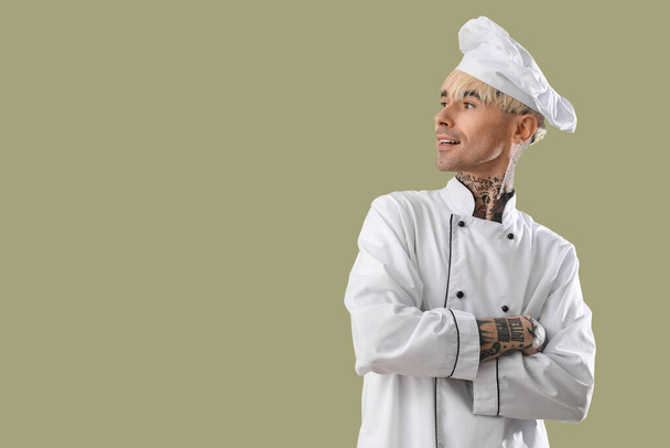 Tattooed male chef on green background - Photo, Image