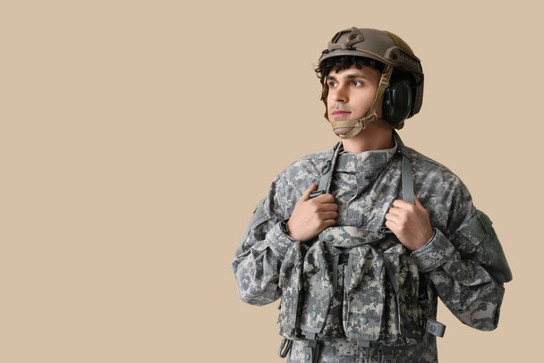 Junger männlicher Soldat auf beigem Hintergrund - Foto, Bild