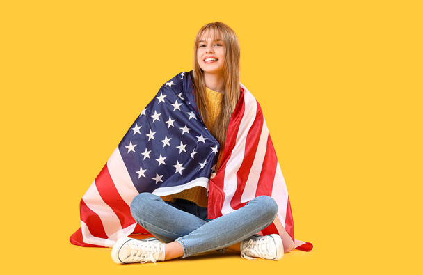 Teini tyttö USA lippu istuu keltaisella taustalla - Valokuva, kuva