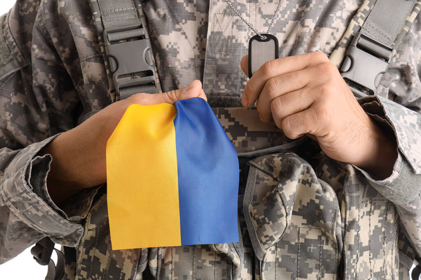 Soldato maschio con bandiera dell'Ucraina su sfondo bianco - Foto, immagini