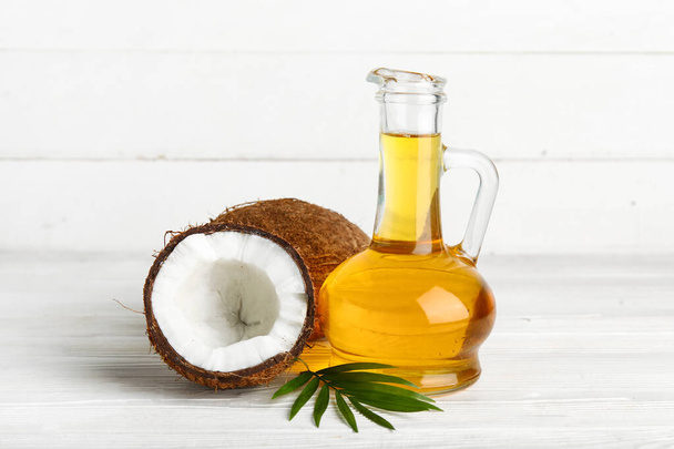 Декантер кокосової косметичної олії на білому дерев'яному фоні - Фото, зображення